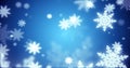 Beautiful festive blue Christmas New Year snowflakes shining falling glowing with blur effect and bokeh on blue background. Royalty Free Stock Photo