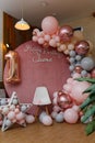 Beautiful festive decorations, pink and grey balloons arch, wooden stars, white chair and number one balloon