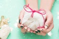 Beautiful festive female manicure. Women`s hands hold a small gift. New Year`s content, balls, sequins, stars