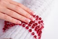 Beautiful festive french manicure on red beads.