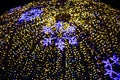 Beautiful festive luminous ball of yellow Christmas lights with blue snowflakes