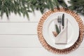 Beautiful festive place setting with cutlery and fir branches for Christmas dinner on white wooden table, flat lay. Space for text Royalty Free Stock Photo