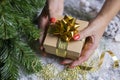 Beautiful festive surprise box gift golden with a bow girl holding in her hands near the christmas tree for new year Royalty Free Stock Photo