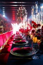 Beautiful festive table setting with fresh red flowers, napkins and candles. Royalty Free Stock Photo