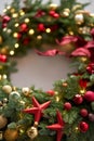 Beautiful festive wreath of fresh spruce on Gray wall. Xmas circlet with red and gold ornaments and balls. Christmas Royalty Free Stock Photo