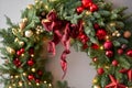 Beautiful festive wreath of fresh spruce on Gray wall. Xmas circlet with red and gold ornaments and balls. Christmas Royalty Free Stock Photo