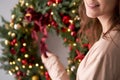 Beautiful festive wreath of fresh spruce in woman hands. Xmas circlet with red and gold ornaments and balls. Christmas Royalty Free Stock Photo