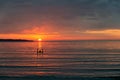 Beautiful fiery sunrise on the beach and a human silhouette holding the rising sun in his hands Royalty Free Stock Photo