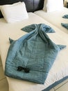 Beautiful figures of sea rays made from blankets, duvet covers on the bed with sunglasses