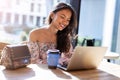 Beautiful Filipino woman using laptop at cafe