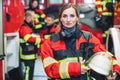 Beautiful fire fighter woman with her helmet standing in the firehouse