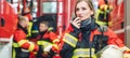 Beautiful fire fighter woman with her helmet standing in the firehouse Royalty Free Stock Photo