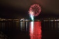 Beautiful firework on night sky in tromsoe city with bridge, cathedral and colorful reflection on the cold fjord water Royalty Free Stock Photo