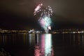 Beautiful firework on night sky in tromsoe city with bridge, cathedral and colorful reflection on the cold fjord water Royalty Free Stock Photo