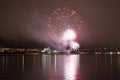 Beautiful firework on night sky in tromsoe city with bridge, cathedral and colorful reflection on the cold fjord water Royalty Free Stock Photo