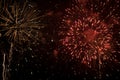 Beautiful fireworks and many bright sparks of red and orange and smoke against the night sky. Concept fire show Royalty Free Stock Photo