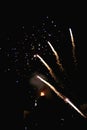 Beautiful fireworks popping apart photographed with a vintage lens in a black night and a bonfire in the background Royalty Free Stock Photo