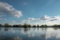 Krásny rybník v Badíne pri Banskej Bystrici. Rybárske miesto. Modrá obloha a mraky nad jazerom. Zrkadlový odraz
