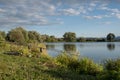 Beautiful fish pond near Badin, Banska Bystrica, Slovakia. Sky and trees mirror reflection in the water. Fishing place. Shining Royalty Free Stock Photo