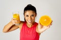 Happy attractive sporty woman holding glass of fresh orange juice and orange fruit Royalty Free Stock Photo