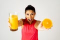 Happy attractive sporty woman holding glass of fresh orange juice and orange fruit Royalty Free Stock Photo