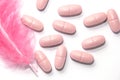 Pills that bring relief. A pink feather next to the pills. Royalty Free Stock Photo