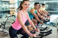 Beautiful fit woman smiling during cardio workout at indoor cycl