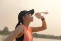 Beautiful fitness athlete woman drinking water after work out exercising on. evening summer Royalty Free Stock Photo