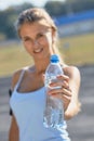 Fitness athlete woman drinking water after work out exercising on sunset evening summer in outdoor portrait Royalty Free Stock Photo