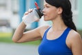 Beautiful fitness athlete woman resting drinking water after work out exercising on beach summer evening in sunny sunshine outdoor Royalty Free Stock Photo