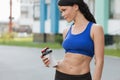 Beautiful fitness athlete woman resting drinking water after work out exercising on beach summer evening in sunny sunshine outdoor Royalty Free Stock Photo