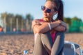 Beautiful fitness athlete woman wearing sunglasses listening music resting after work out exercising on summer evening Royalty Free Stock Photo