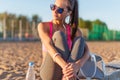 Beautiful fitness athlete woman wearing sunglasses listening music resting after work out exercising on summer evening Royalty Free Stock Photo