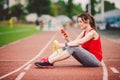 Beautiful fitness girl uses smartphone at stadium after workout. Sports and healthy. Sport woman use of cellphone inside sport Royalty Free Stock Photo