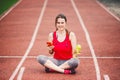 Beautiful fitness girl uses smartphone at stadium after workout. Sports and healthy. Sport woman use of cellphone inside sport Royalty Free Stock Photo