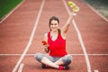 Beautiful fitness girl uses smartphone at stadium after workout. Sports and healthy. Sport woman use of cellphone inside sport Royalty Free Stock Photo