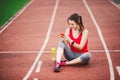 Beautiful fitness girl uses smartphone at stadium after workout. Sports and healthy. Sport woman use of cellphone inside sport Royalty Free Stock Photo
