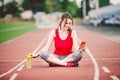 Beautiful fitness girl uses smartphone at stadium after workout. Sports and healthy. Sport woman use of cellphone inside sport Royalty Free Stock Photo