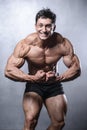 Beautiful fitness male model posing in studio on white grey back Royalty Free Stock Photo