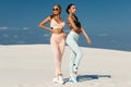 Beautiful fitness models in sportswear. Couple athletic girls in leggings outdoor Royalty Free Stock Photo