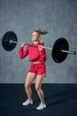 Beautiful fitness woman lifting barbell. Sporty woman lifting weights. Fit girl exercising building muscles. Royalty Free Stock Photo