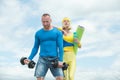 Beautiful fitness young sporty couple with dumbbell and sports inventory over sky background. Young athlete woman Royalty Free Stock Photo