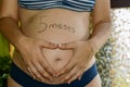 Beautiful Five month pregnant woman showing her tummy drawing a heart on it with her hands. June 25, 2019. Madrid. Spain. Royalty Free Stock Photo