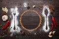 Beautiful flat lay composition with different spices, silhouettes of cutlery and plate on wooden background. Space for text Royalty Free Stock Photo