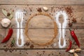 Beautiful flat lay composition with different spices, silhouettes of cutlery and plate on wooden background. Space for text Royalty Free Stock Photo