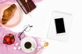 Beautiful flatlay arrangement with croissant, cup of coffee, fresh strawberries, smartphone with black copyspace and other busines Royalty Free Stock Photo