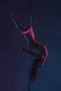 beautiful flexible young woman exercising with pole