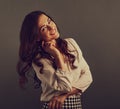 Beautiful flirting happy woman with long brown healthy hair style in white shirt and skirt fashion clothing. Closeup studio Royalty Free Stock Photo