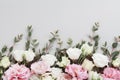 Beautiful floral border of pastel flowers and green eucalyptus leaves on gray table top view. Flat lay composition Royalty Free Stock Photo