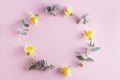 wreath made of yellow narcissus flowers and eucalyptus leaves on pastel pink background Royalty Free Stock Photo